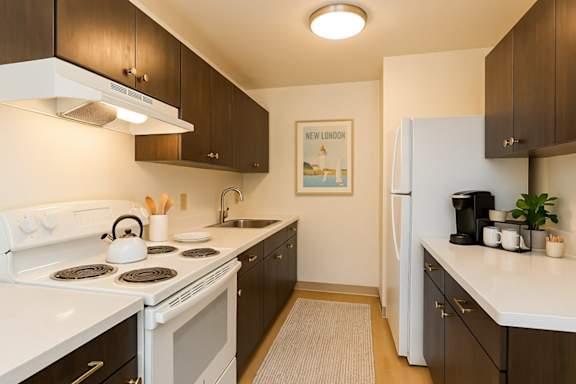 A kitchen with a white stove top oven and a white refrigerator.
