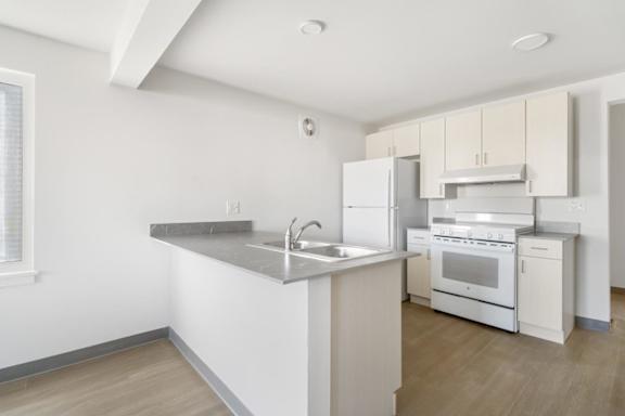 A kitchen with white appliances and a marble countertop.