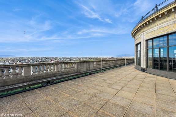 A balcony with a railing and a building on the right side.