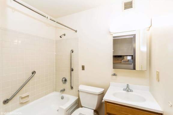 A white bathroom with a toilet, sink, and bathtub.