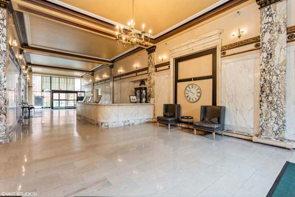 A large, well-lit lobby with a marble floor and a large clock on the wall.