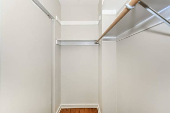 A white hallway with a wooden floor and white walls.