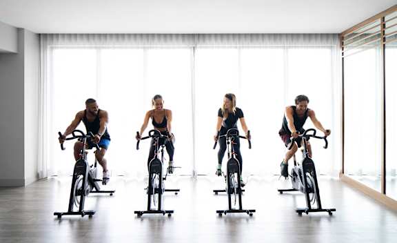 Four people are riding stationary bikes  at Palma, Doral, FL