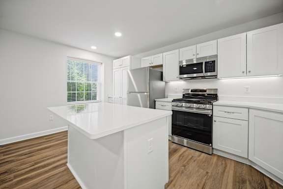 A modern kitchen with white cabinets and a large island.