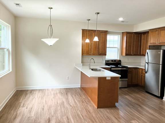 A kitchen with wooden cabinets and a white island.
