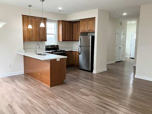 A kitchen with wooden cabinets and a refrigerator.