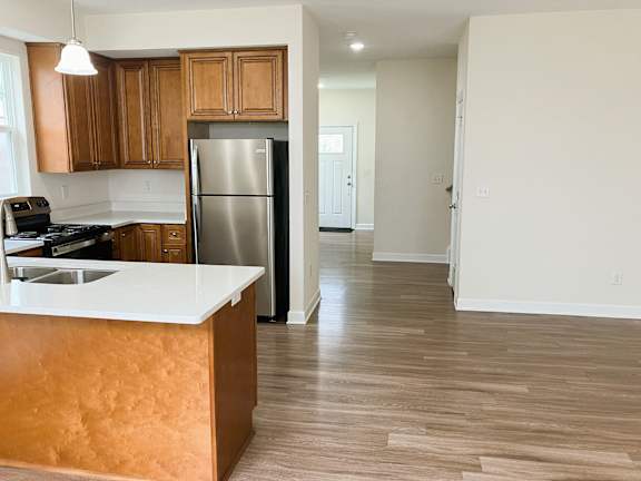 A kitchen with wooden cabinets and a white counter.