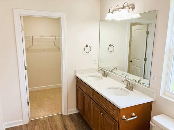 A bathroom with a wooden vanity and a toilet.