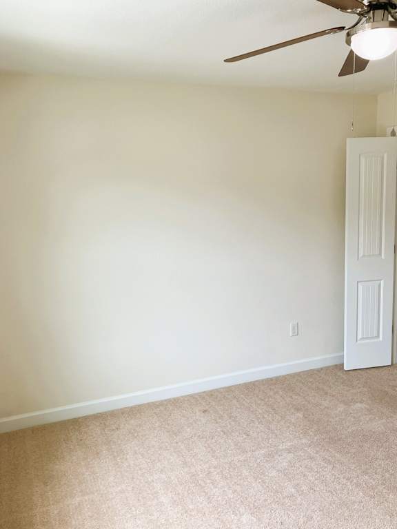 A room with a ceiling fan and a door.