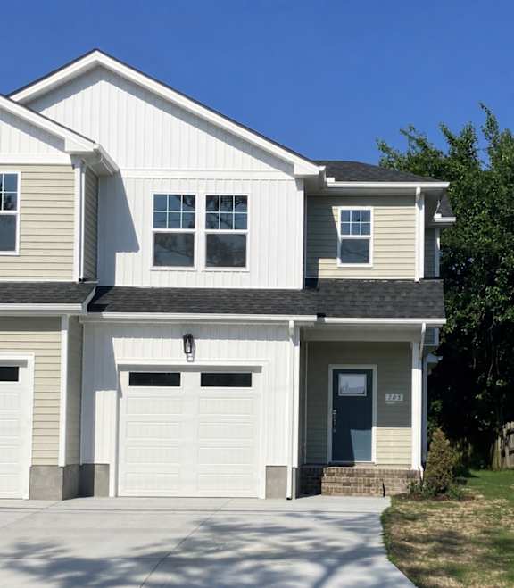 A two-story house with a white garage door.