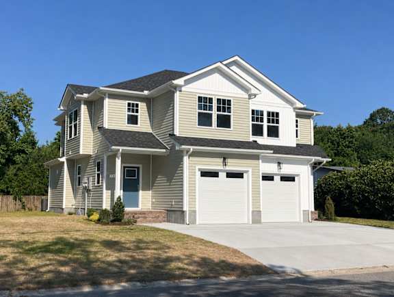 A two-story house with a garage on the right side.