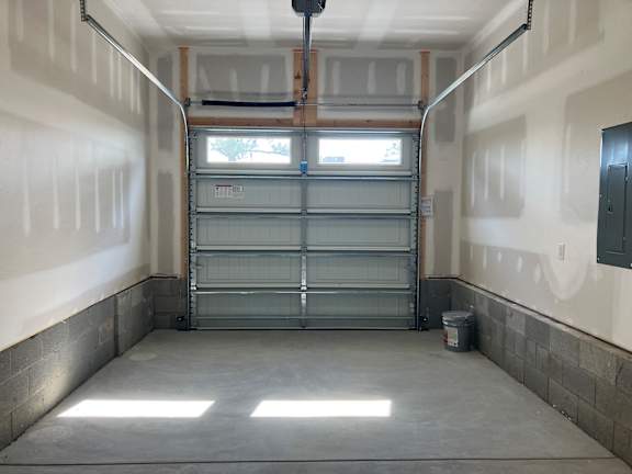 A garage with a metal gate and a window.