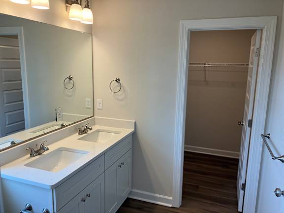 A bathroom with a white sink and a mirror above it.