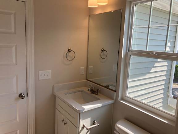 A bathroom with a sink, mirror, and toilet.