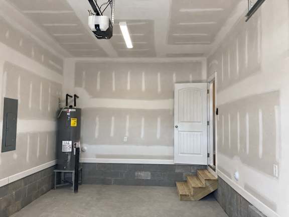 A room under construction with a white door and a window.