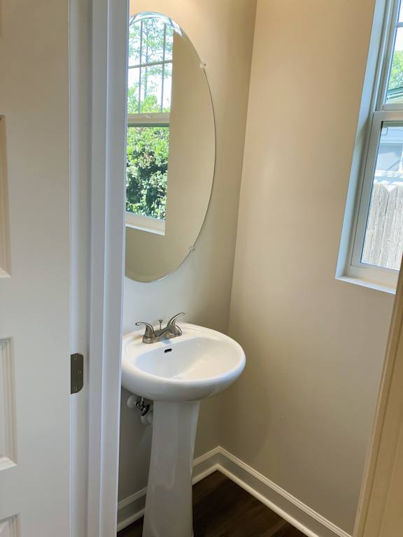 A white sink in a bathroom with a round mirror above it.