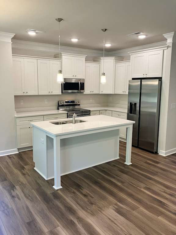 A kitchen with a white island and wooden floors.