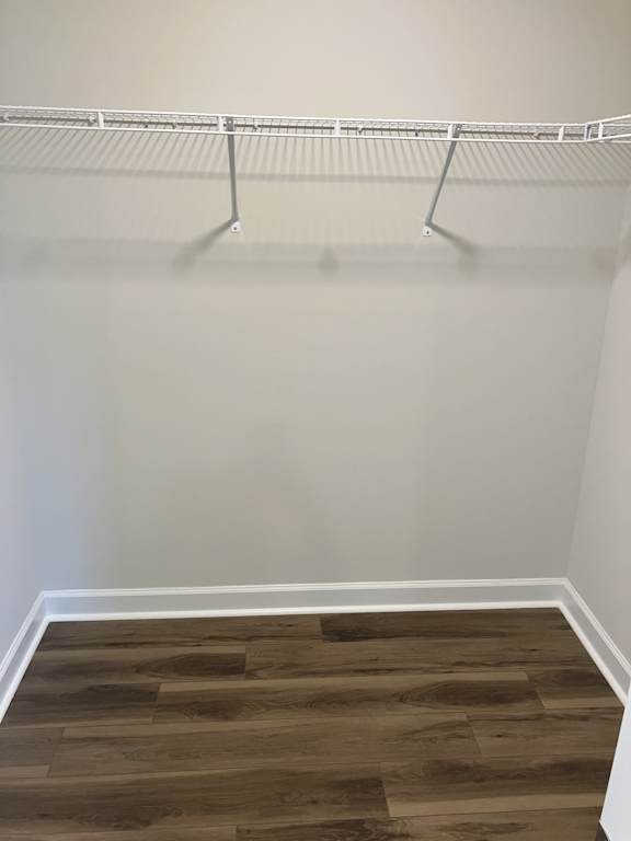 Empty room with a clothes hanger and wooden floor.