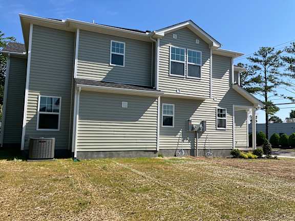 A two-story house with a gray siding and a brown roof.