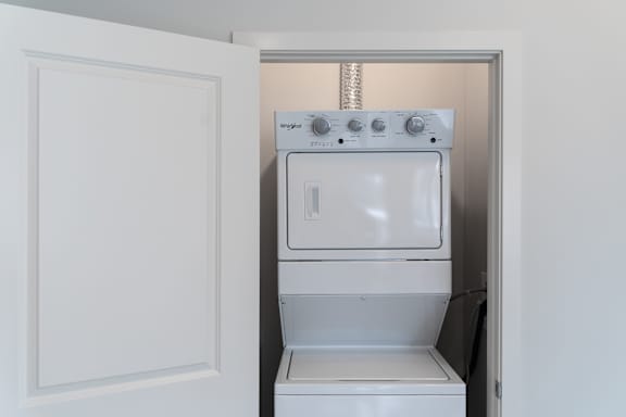 A white oven with a control panel on top is installed in a wall.