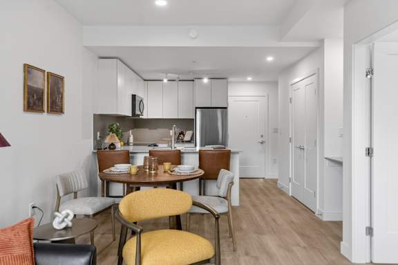 A modern kitchen with a dining table and chairs.