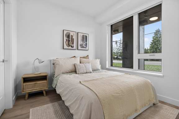 A bedroom with a large bed and two pictures on the wall.