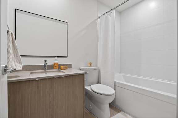 A bathroom with a toilet, sink, and bathtub.
