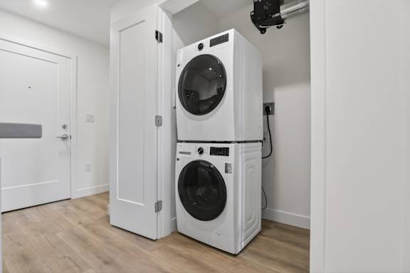 A white washer and dryer stacked on top of each other in a room.