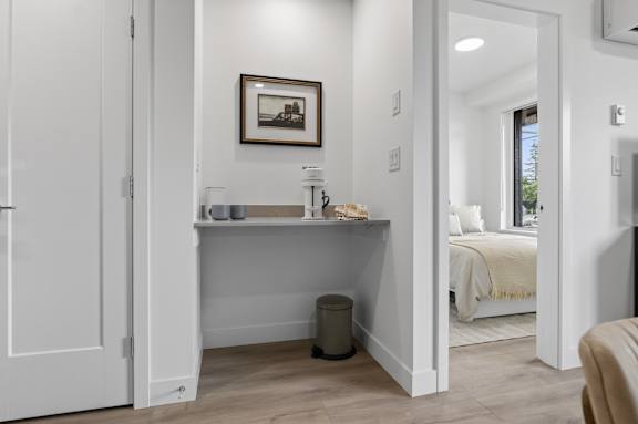 A white room with a bed and a picture on the wall.