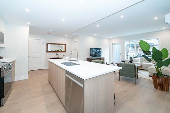 A modern kitchen with a large island and a dining area.