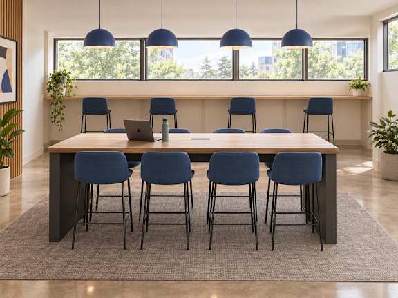 A conference room with a long table and blue chairs.