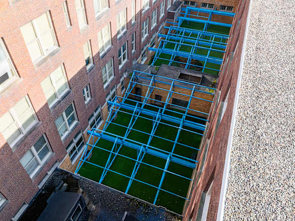 A green field surrounded by a red brick building.