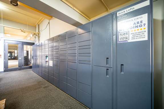 A long row of lockers are lined up in a room.