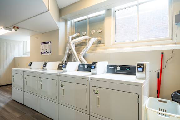A series of white washing machines are lined up in a row.