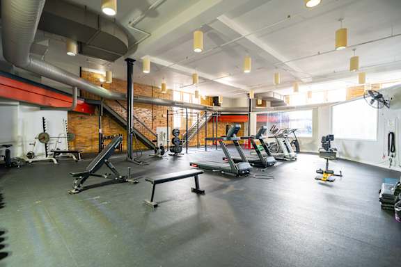 A gym with treadmills, weights, and exercise equipment.