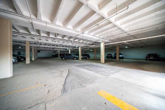 A parking garage with a yellow line on the ground.
