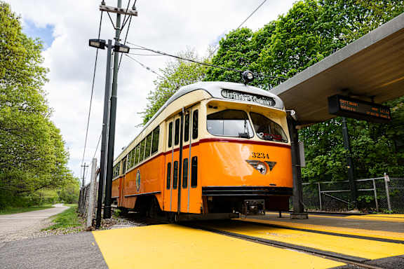A yellow and white train is at the station.