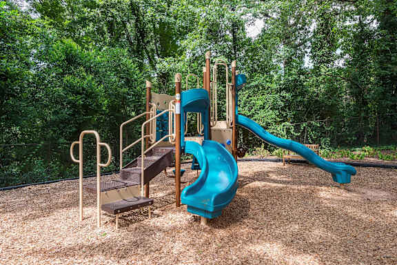 A playground with a blue slide and a brown wooden platform.