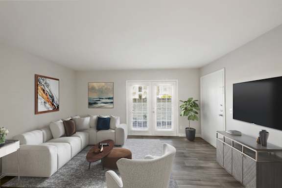 A living room with a white couch, a brown coffee table, and a painting on the wall.