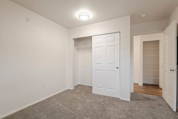A white door is in the center of a room with a carpet floor.