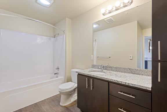 A bathroom with a toilet, sink, and mirror.