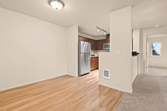 A kitchen with a refrigerator, microwave, and oven.