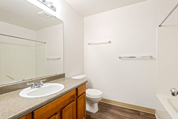 A bathroom with a sink, toilet, and bathtub.
