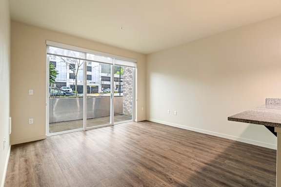 A room with a sliding glass door leading to a balcony.