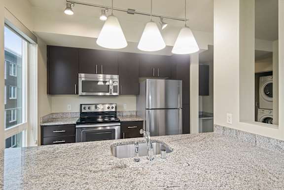 A kitchen with granite countertops and stainless steel appliances.