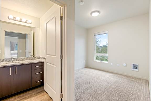 A bathroom with a sink, mirror, and cabinets is shown.