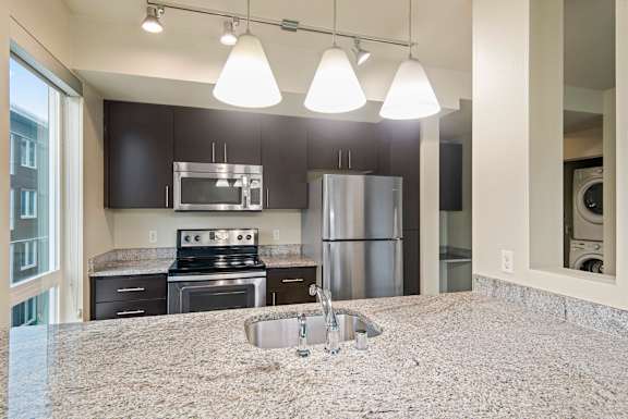 A kitchen with granite countertops and stainless steel appliances.