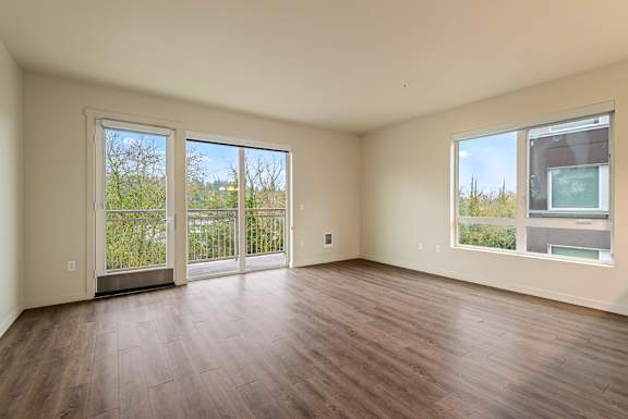 Empty room with sliding glass doors and wood flooring.