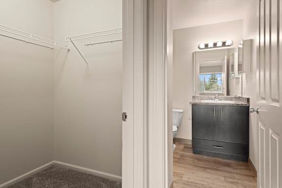 A bathroom with a toilet, sink, and mirror.