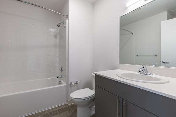 A white bathroom with a sink, toilet and bathtub.